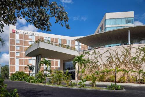 a building with palm trees in front of it at Hilton Garden Inn Cancun Airport in Cancún