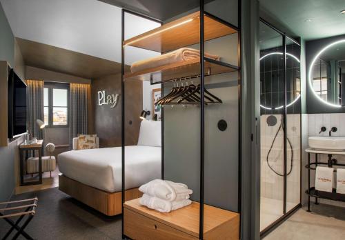 um quarto com uma cama e uma casa de banho com um lavatório em Se Catedral Hotel Porto, Tapestry Collection By Hilton no Porto