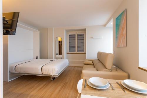 Apartamentos&Spa Mundaka Port في مونداكا: غرفة نوم بسرير واريكة وطاولة