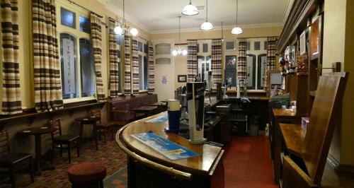 a restaurant with a bar with tables and chairs at Anfield Accommodation part of The Twelfth Man Public House in Liverpool