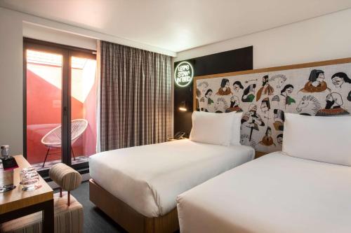 a hotel room with two beds and a desk at Se Catedral Hotel Porto, Tapestry Collection By Hilton in Porto