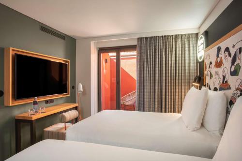 a hotel room with a bed and a television at Se Catedral Hotel Porto, Tapestry Collection By Hilton in Porto