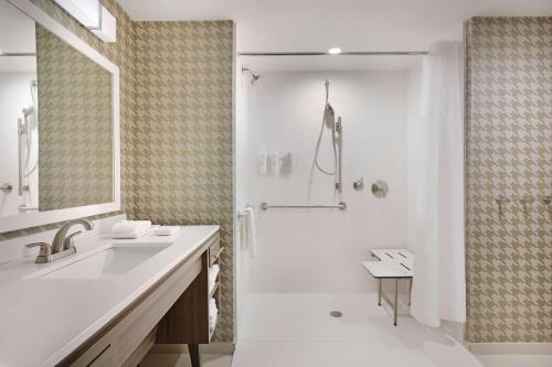 a white bathroom with a shower and a sink at Home2 Suites By Hilton Richmond Short Pump in Richmond