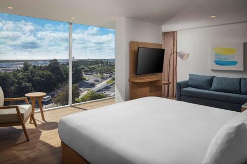 a hotel room with a bed and a large window at Hilton Garden Inn Cancun Airport in Cancún