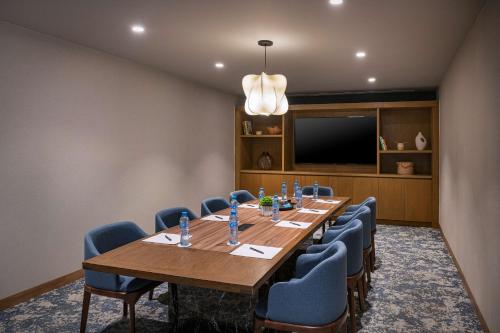 a conference room with a large wooden table and blue chairs at Hilton Garden Inn Cancun Airport in Cancún