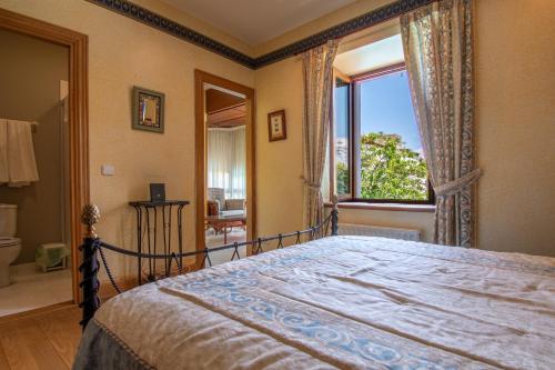 a bedroom with a bed and a large window at Villa Ganbara in Villava