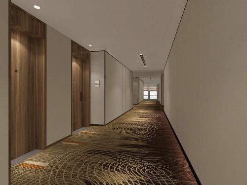 a hallway with a long corridor with wooden floors at Hilton Garden Inn Jinzhou Central Street in Jinzhou