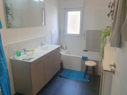 a bathroom with a sink and a tub and a toilet at Chez Frédéric in Saint Malo