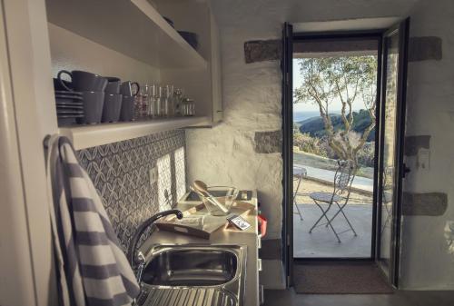 a kitchen with a sink and a door to a patio at Afentiko Pigadi in Methoni