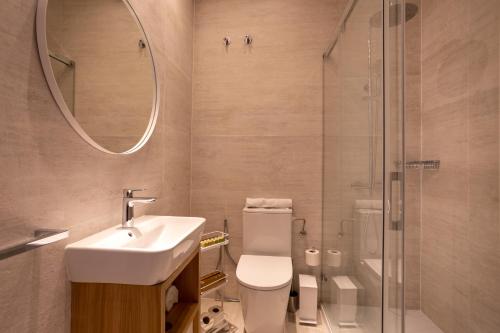 a bathroom with a toilet and a sink and a shower at Apartamentos&Spa Mundakaport in Mundaka