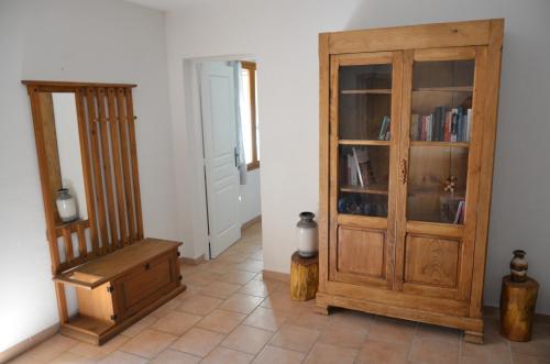 um quarto com uma estante de livros e um armário de madeira em Maison Amandre en Pleine Nature - Mas Lou Castanea em Collobrières