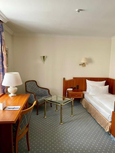 a hotel room with a bed and a table and a desk at Antonappartements in Dresden