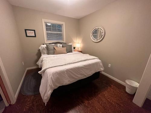um quarto com uma cama grande com lençóis brancos e almofadas em CAIA Lakeside Retreat - Sunken Lake em New Minas