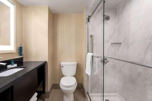 W łazience znajduje się toaleta i przeszklony prysznic. w obiekcie Doubletree By Hilton Pointe Claire Montreal Airport West w mieście Pointe-Claire