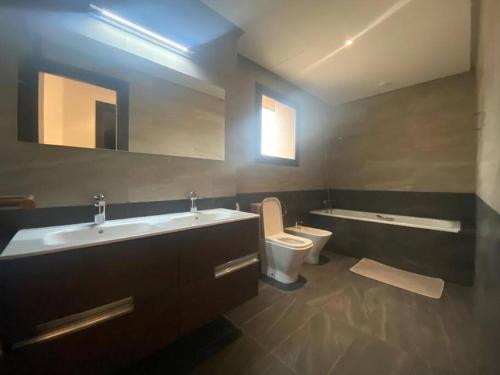 ein Badezimmer mit einem Waschbecken, einem WC und einer Badewanne in der Unterkunft New Luxury Duplex Apt Taghazout in Taghazout
