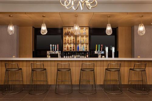a bar with four stools in a restaurant at Doubletree By Hilton Pointe Claire Montreal Airport West in Pointe-Claire