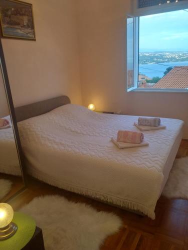 a bedroom with a bed with a large window at Mari in Opatija