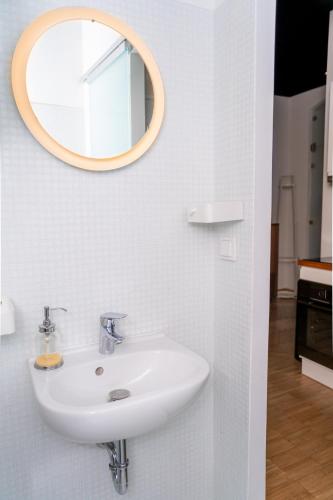 a bathroom with a sink and a mirror on the wall at K57 Old Town Apartment in Pécs