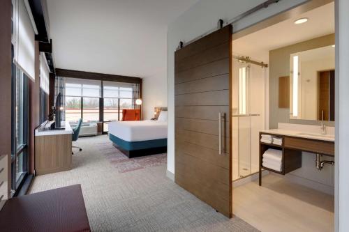 a hotel room with a bed and a bathroom at Hilton Garden Inn Haymarket in Haymarket