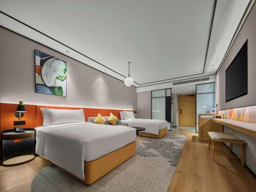 a hotel room with two beds and a television at Hilton Garden Inn Huzhou Anji Phoenix Mountain in Anji