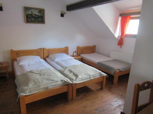 2 camas individuales en una habitación con ventana en Pensiunea Gasthof Michelsberg, en Cisnădioara