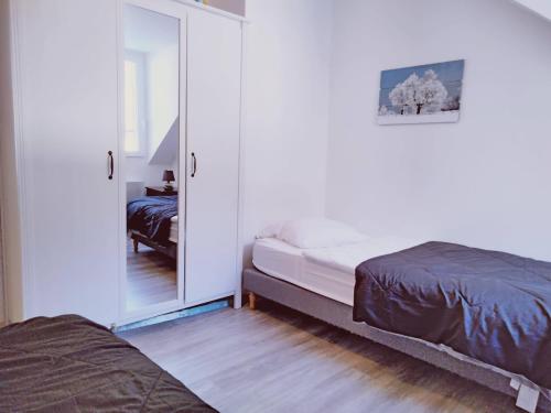 une chambre avec deux lits et un miroir dans l'établissement T3 HYPER CENTRE MONT-DORE, à Le Mont-Dore