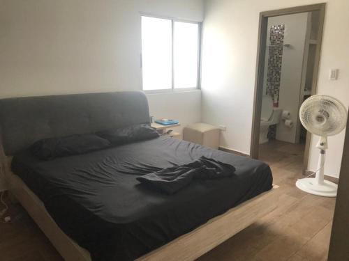 a bedroom with a bed and a fan and a window at Beautiful & Central Penthouse in Quibdó in Quibdó