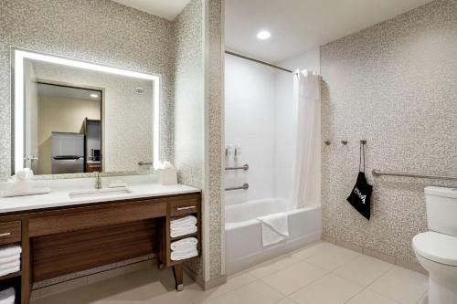 a bathroom with a sink and a tub and a toilet at Home2 Suites By Hilton Minneapolis University Area in Minneapolis