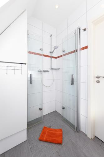 a bathroom with two shower stalls and an orange rug at Ferienhaus Daniela in Neuharlingersiel