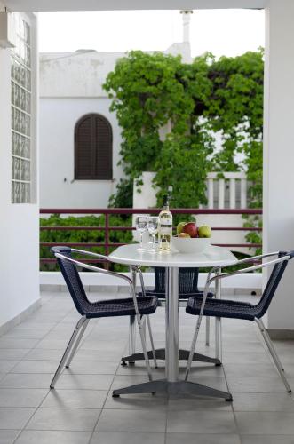 a white table with two chairs and a bottle of wine at Markakis Apartments in Elounda