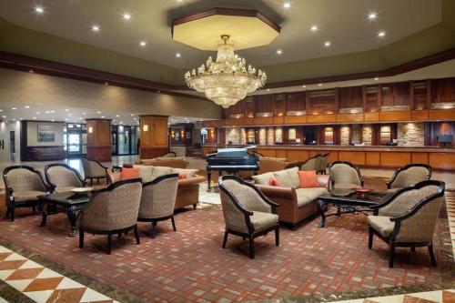 a lobby with tables and chairs and a piano at DoubleTree by Hilton Cherry Hill Philadelphia in Cherry Hill