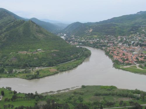 an aerial view of a river with a town and mountains at Guesthouse Mtskheta-Kapanadze in Mtskheta