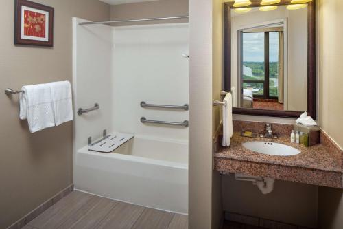 een badkamer met een wastafel, een bad en een spiegel bij DoubleTree by Hilton Cherry Hill Philadelphia in Cherry Hill