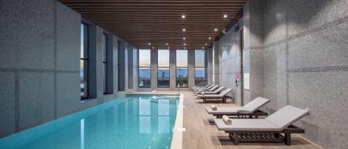 a pool with chaise lounge chairs and a swimming pool at Hilton Garden Inn Erzurum in Erzurum