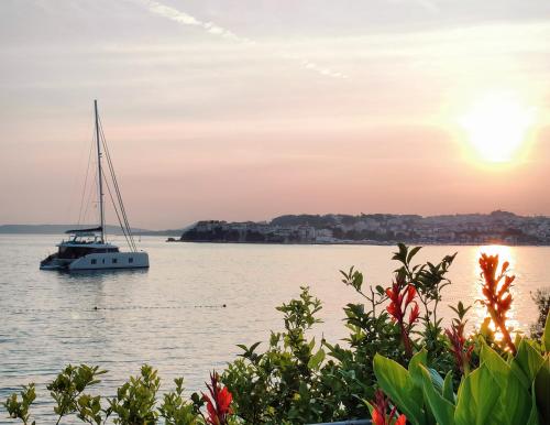 a sailboat in the water at sunset at VILLA JURAS in Podstrana