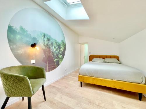 a bedroom with a bed and a green chair at Niort - Hyper-Centre - Appartements en Duplex ou Triplex - Wifi Fibre - NOUVEAU in Niort