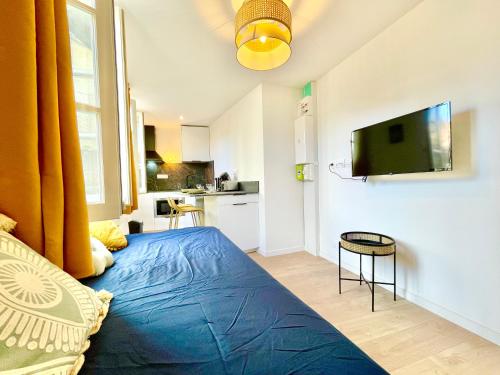 a bedroom with a bed and a tv on a wall at Niort - Hyper-Centre - Appartements en Duplex ou Triplex - Wifi Fibre - NOUVEAU in Niort
