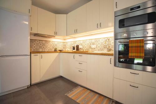 une cuisine avec des armoires blanches et un four à plaques de cuisson dans l'établissement Appartement Cosy - jardin Terrasse privée-Free parking 5MN DISNEY, à Chessy