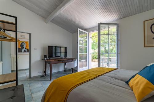 1 dormitorio con 1 cama y escritorio en una habitación en Mazet Pierre de Vers - Le Mas des Olivers Nîmes, en Nimes