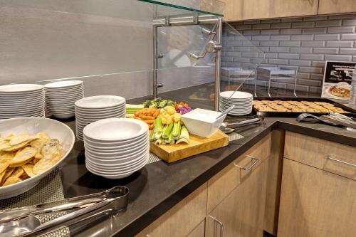 a kitchen with plates and food on a counter at Homewood Suites By Hilton Oak Creek Milwaukee in Oak Creek