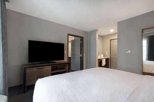 a bedroom with a bed and a flat screen tv at Homewood Suites By Hilton Oak Creek Milwaukee in Oak Creek