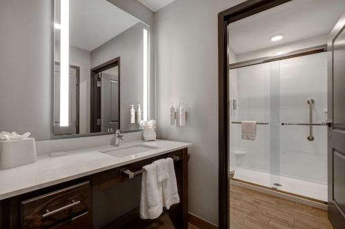 a bathroom with a sink and a shower with a mirror at Homewood Suites By Hilton Oak Creek Milwaukee in Oak Creek