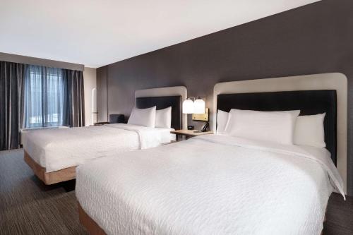 a hotel room with two beds and a window at Homewood Suites By Hilton Oak Creek Milwaukee in Oak Creek