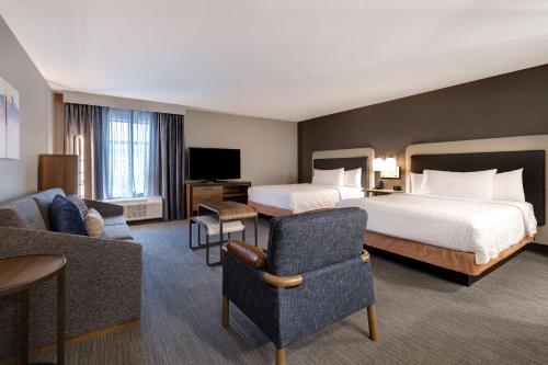 Pokój hotelowy z dużym łóżkiem i kanapą w obiekcie Homewood Suites By Hilton Oak Creek Milwaukee w mieście Oak Creek