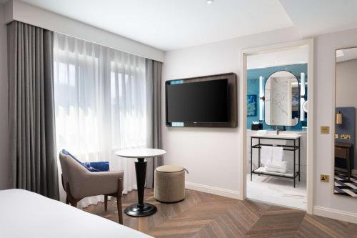 a hotel room with a bed and a large mirror at Lost Property St Pauls London, Curio Collection By Hilton in London