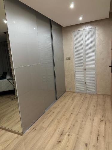a room with a sliding glass door and a wooden floor at Premium Apartament Polna Szczecinek in Szczecinek