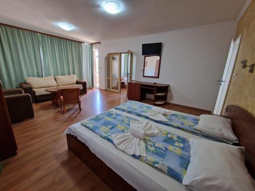 Hotel Sunrise في رافدا: غرفة نوم بسرير كبير وغرفة معيشة