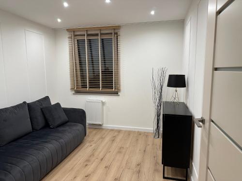 a living room with a couch and a window at Premium Apartament Polna Szczecinek in Szczecinek
