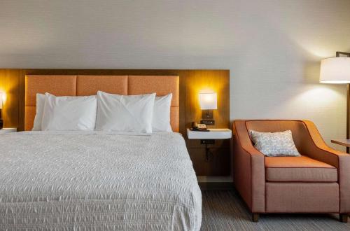 a hotel room with a bed and a chair at Hampton Inn Colorado Springs Northeast in Colorado Springs