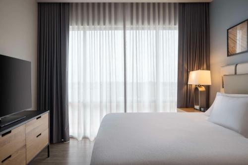 a bedroom with a large bed and a large window at Embassy Suites By Hilton Bowling Green in Bowling Green